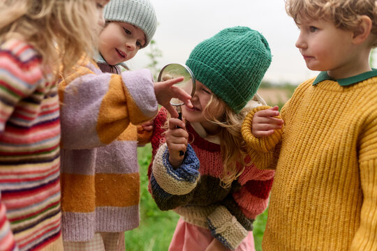 Children Investigating Nature With Magnifying Glass