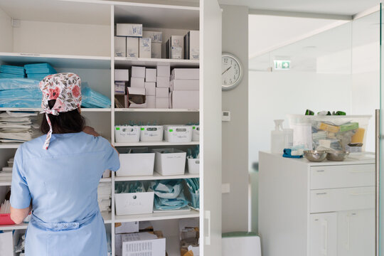 Nurse Organizing Supplies in a Medical Storage Room at a Clinic