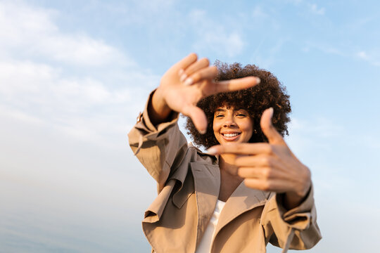 Happy woman framing view with hands outdoors
