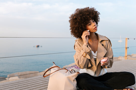 Woman enjoying music with earbuds by the sea