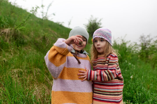 Children Discovering a Snail Together