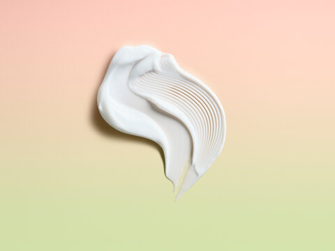 Smear of cream against a pink / green background 