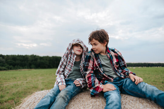 Boys Play Joyfully on a Haystack in the Countryside