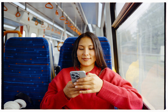 Smiling woman typing on smartphone