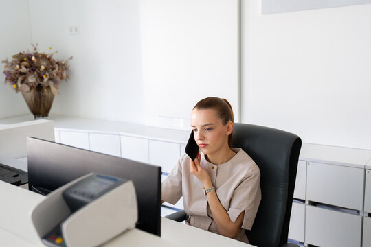Receptionist Talks on Phone While Working in Office 