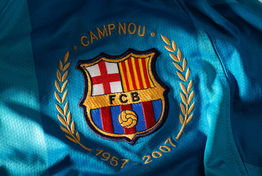 Embroidered FC Barcelona crest with Camp Nou anniversary details on blue football jersey fabric background.