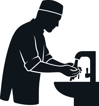 Muslim man performing ablution wudu at sink with running water wearing traditional kufi cap.