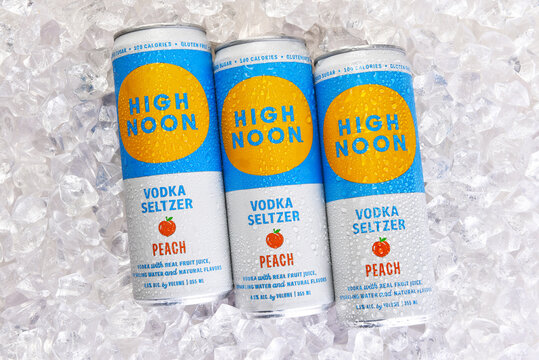IRVINE, CALIFORNIA - 24 JUN 2026: Three cans of High Noon Vodka Seltzer Peach flavor adult beverage on a bed of ice.