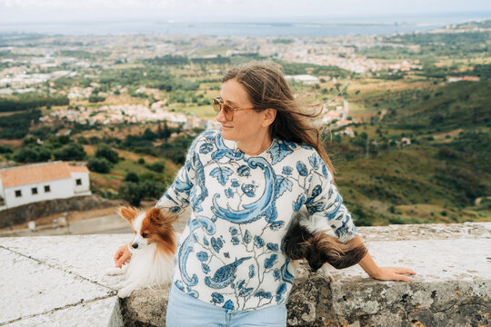 Woman relaxing with dogs overlooking countryside landscape outdo