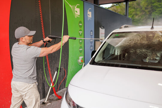 A man washing his car at a self-service car wash