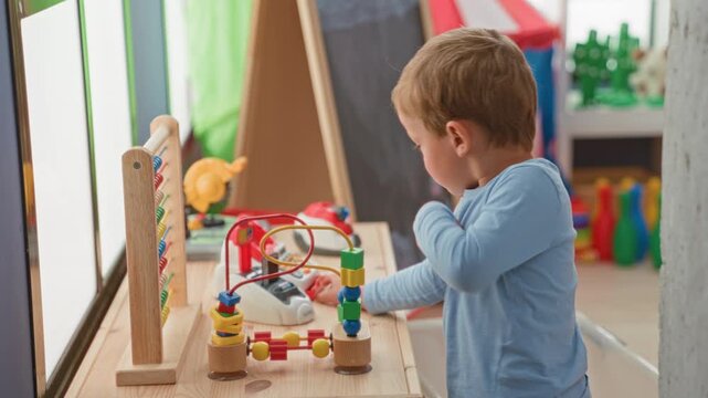 Boy playing with wooden bead maze toy, hands moving beads on table in building; curiosity learning concentration.