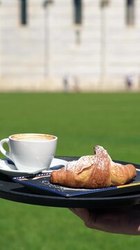 Morning espresso and fresh pastry enjoyed in Piazza dei Miracoli, Tuscany, Italy