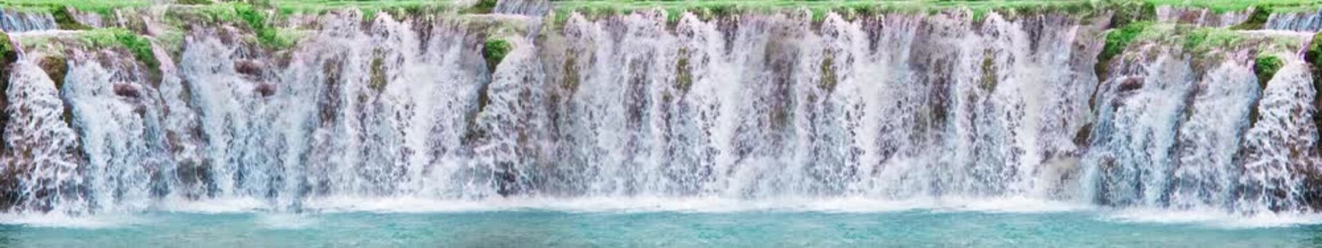Wide Panoramic Waterfall Cascading Over Rocky Cliff into Turquoise Pool Nature Background &mdash; Widescreen Loop