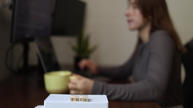 Technology work routine as woman drinks coffee while coding at computer highlighting developer lifestyle programming focus productivity and modern digital workspace