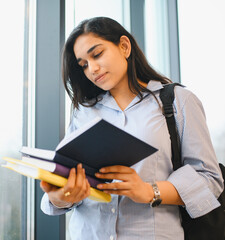 Indian student studying books thinking about education