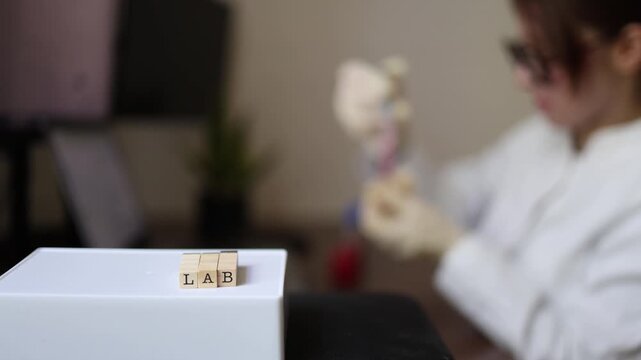 Laboratory researcher examines sample in test tube while reviewing data on computer Scientific testing analysis and modern research workflow