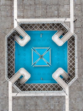 Aerial view of the geometric courtyard and blue water fountain of Faisal Masjid in Islamabad, Islamabad Capital Ter, Pakistan.