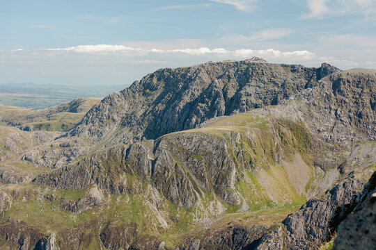 Rugged mountain crags and ridge above a deep cwm with distant plains