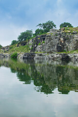 Fototapeta premium Tarpania Lake, Marble Lake, Blue Dam, Patal Dam or Durga Bera,a scenic lake in the Ajodhya Hills of Purulia, West Bengal, India. Deep blue water surrounded by sharp, white, marble-like rocky cliffs.