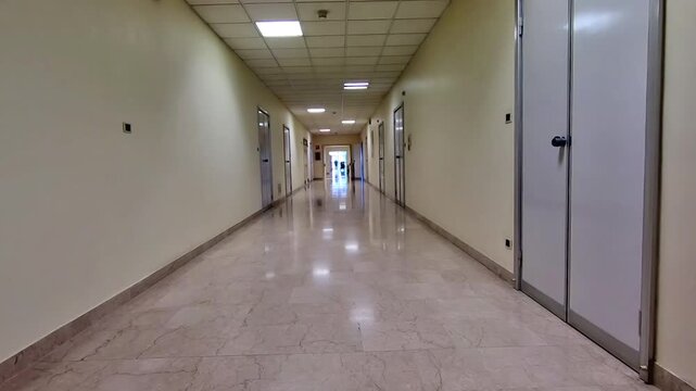 Long walkway corridor with white walls of a hospital lane interior. Blurred medical and healthcare background.