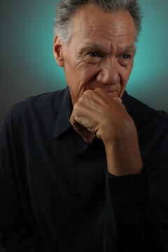 Older Senior Man looking serious with his hand on his chin in deep thought