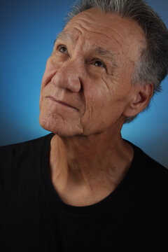 Older Senior Man looking slightly up with a serious look on his face. 