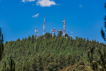 Obraz premium Antenas de telecomunicaciones en medio del bosque.