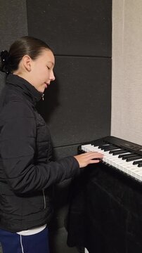 garota tocando teclados de piano em aula 