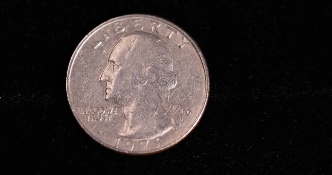 an old worn quarter dollar coin on black velvet fabric, one old, worn, scratched 25-cent coin in close-up on black velvet 