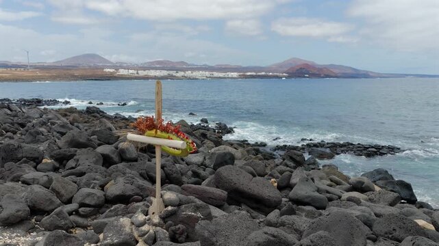 Maritime Memorial Cross Handcrafted from Wooden Paddles and Adorned with Floral Tributes for People Lost at Sea