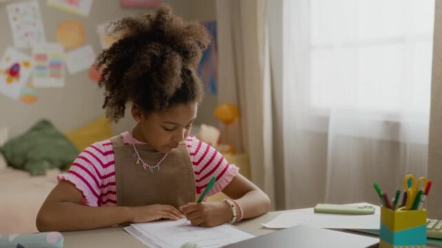 African American child studying at desk, writing in notebook and thinking. Video perfect for marketing campaigns focused on primary education, e-learning platforms, or school supplies
