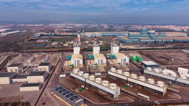 Aerial view of a combined cycle gas turbine power plant with cooling towers, exhaust stacks, and electrical substation in an industrial zone, environment pollution concept