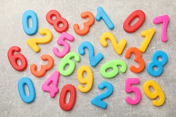 Fototapeta premium Many colorful numbers on grey textured table, flat lay