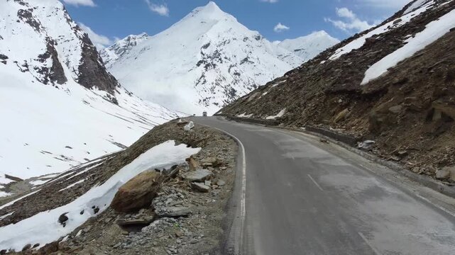 Drone View of Vehicle Driving Through Snow Covered Himalayan Pass