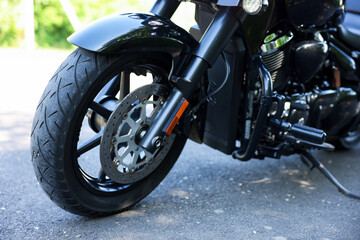 Obraz premium Modern black motorcycle parked on road outdoors, closeup