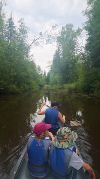 family with kids on river boat trip with rowboat