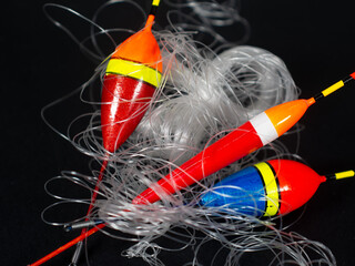 Tangled fishing floats with clear line on dark background © VexoraImages