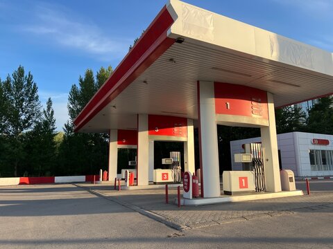 An abandoned, closed gas station with fuel pumps and a closed convenience store under a blue sky. Crisis, lack of gasoline, shortages, inflation. No logos or people