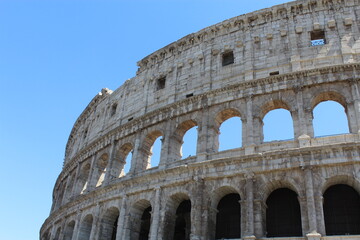 Obraz premium ROME, ITALY - JUNE 5, 2016: Close-up exterior view of the Colosseum arches against clear blue sky