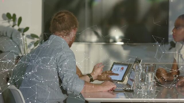 Team lead tapping tablet, causing animated network overlay over pie chart around table for business
