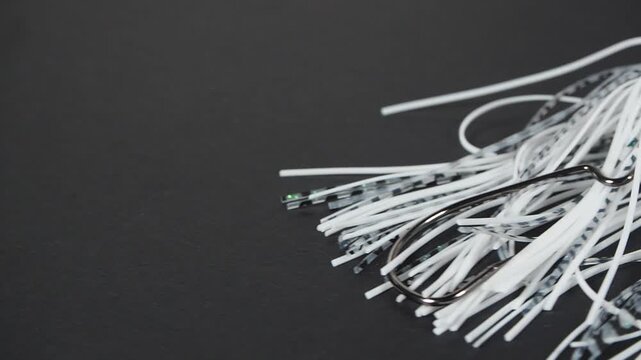Bladed jig fishing lure moving on black background