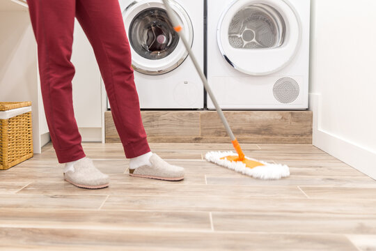 Cleaning floor in laundry room in modern house