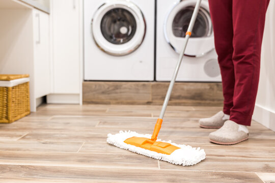Cleaning floor in laundry room in modern house