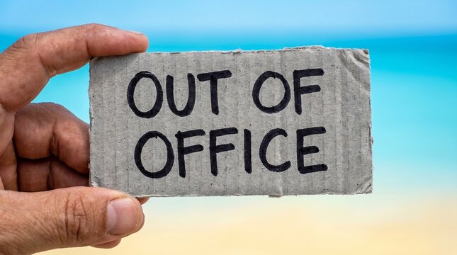 Hand Holding Out Of Office Handwritten Cardboard Sign Blur