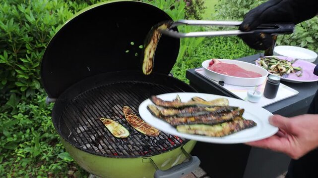 Lund, Sweden Zucchini cooking over an outdoor charcoal barbecue.