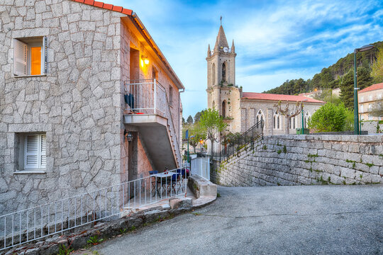 Amazing evening cityscape with Parish Church of the Assumption in Zonza village with typical stone houses