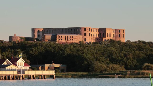 Borgholm, Sweden A view of the Borgholm Castle and the old cold water bathhouse in the city harbor during a midsummer sunset. 