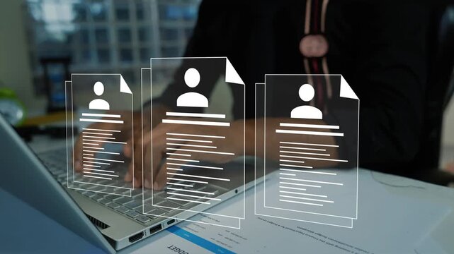 Close view of a person using a laptop with digital hologram resume icons above the desk, showing online hiring job search recruitment employee records and human resources work