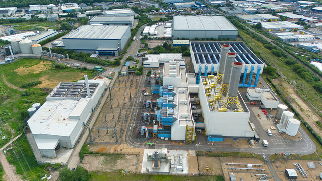 Aerial view of Rye House Power Station featuring industrial buildings, cooling towers, and surrounding warehouses in an industrial area in Hoddesdon, England, United Kingdom.