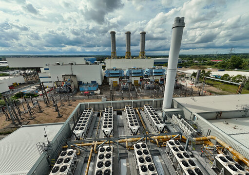 Aerial view of Rye House Power Station featuring industrial cooling units, tall exhaust stacks, and electrical infrastructure in Hoddesdon, England, United Kingdom.